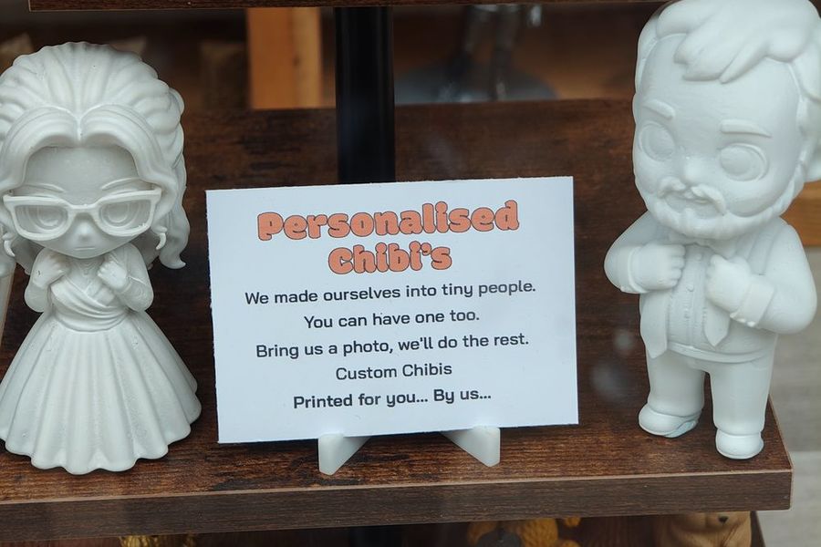 Personalised chibi figures next to their sign in the window